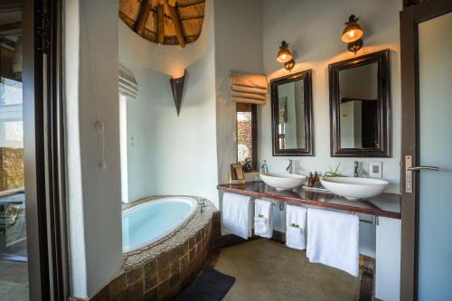 a bathroom with two sinks and a bath tub at The Royal Madikwe Luxury Safari Lodge in Madikwe Game Reserve