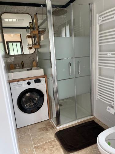 une machine à laver dans une salle de bain avec douche dans l'établissement Appartement neuf proche de la rochelle, à Puilboreau