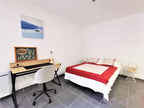 - une chambre avec un bureau et un lit avec un couvre-lit dans l'établissement L'ensoleillade, à Sérignan