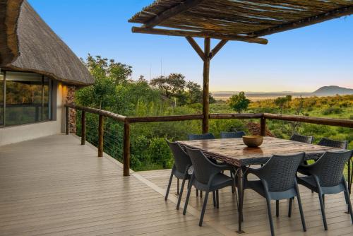 a wooden deck with a wooden table and chairs at The Royal Madikwe Luxury Safari Lodge in Madikwe Game Reserve