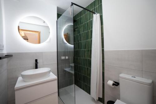 Un baño con lavabo, inodoro y espejo. en NEPTUNO 2C MENYBER, en Nerja