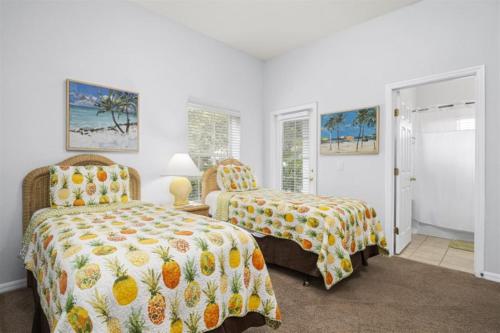 a bedroom with two beds with pineapple bedskirts at Orlando Theme Park Pool Homes in Kissimmee
