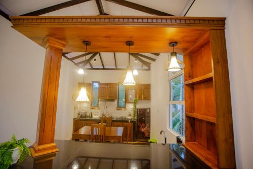 a kitchen with wooden beams and a dining room at Eleena House in Galle
