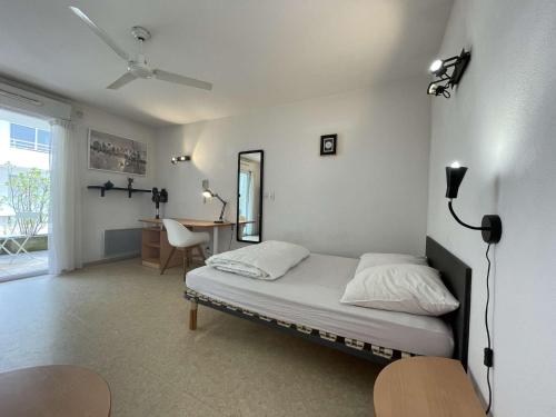 une chambre avec un lit et un bureau dans une pièce dans l'établissement Appt Studio LA ROCHELLE - LR030-E24, à La Rochelle