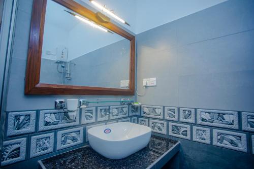 a bathroom with a large mirror and a sink at Eleena House in Galle