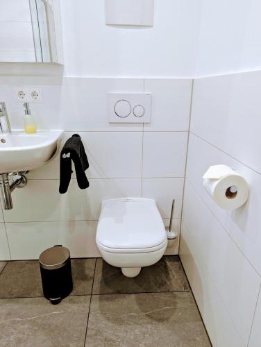 a white bathroom with a toilet and a sink at Apartment del Mardy in Ostfildern