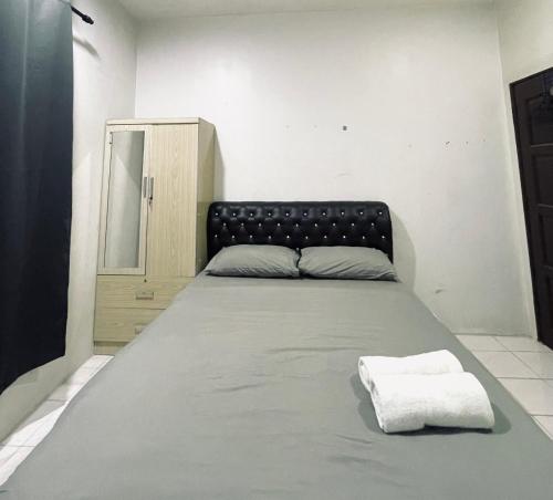 a large bed with a black headboard in a room at Casaria Beach in Paka