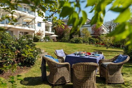 a table with a blue table cloth and chairs in a yard at Techts Apartmenthaus in Timmendorfer Strand
