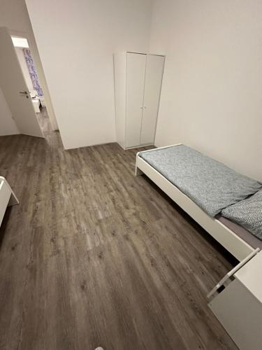 a bedroom with a bed and a wooden floor at Wunderschöne Ferienwohnung in Leipzig Taucha 1 OG rechts in Taucha