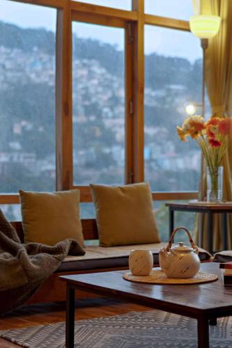a living room with a couch and a table at StayVista at Gassa Home with Mountain View, BBQ, Lawn at Gangtok in Gangtok