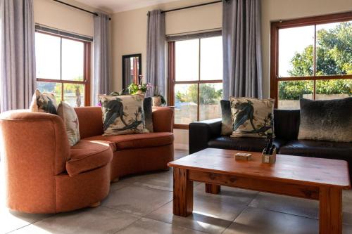 a living room with two couches and a coffee table at Serene Langebaan Getaway with Garden and pool views in Langebaan