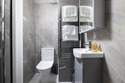 a bathroom with a white toilet and a sink at Charmstay Kensington Olympia in London
