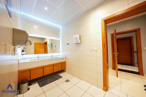 a bathroom with a sink and a mirror at Romera Hotel in Jeddah