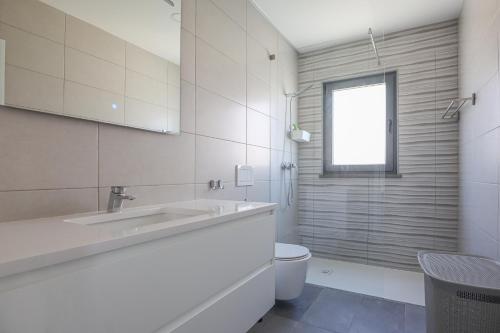 アルブフェイラにあるVilla Soares - Centro Albufeira - For Families - BY BEDZYの洗面台とトイレを備えた白いバスルーム