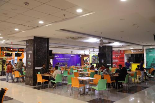 a restaurant with people sitting at tables and chairs at Hotel Bellamont in Mumbai
