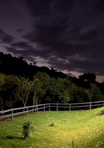 a fence in a field with a horse in it at Loft do Lessa in Ouro Preto