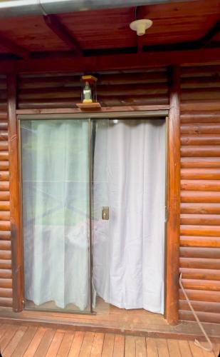 a sliding glass door in a wooden house at Loft do Lessa in Ouro Preto