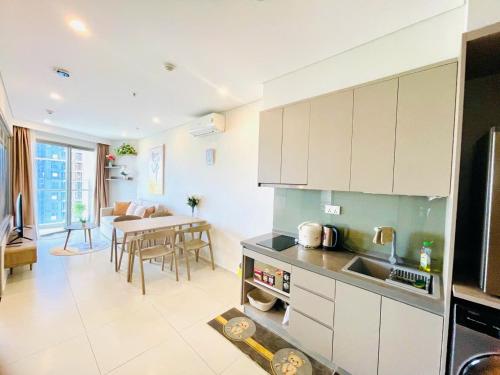 a kitchen with white cabinets and a dining room with a table at The Sóng Vũng Tàu Hideaway in Vung Tau