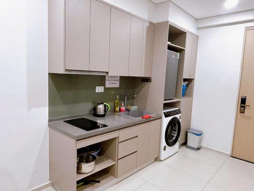 a kitchen with white cabinets and a washer and dryer at The Sóng Vũng Tàu Hideaway in Vung Tau