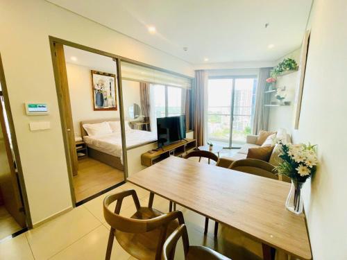 a living room with a table and a bedroom at The Sóng Vũng Tàu Hideaway in Vung Tau