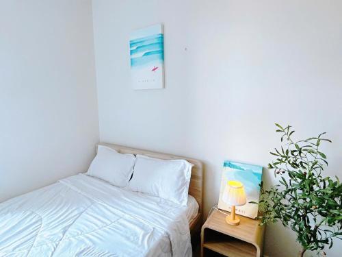 a bedroom with a bed and a table with a plant at The Sóng Vũng Tàu Hideaway in Vung Tau