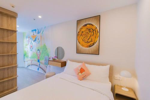 a bedroom with a white bed and a painting on the wall at The Sóng Vũng Tàu Hideaway in Vung Tau