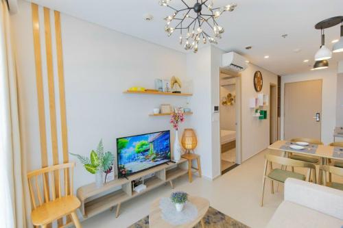 a living room with a television and a dining room at The Sóng Vũng Tàu Hideaway in Vung Tau
