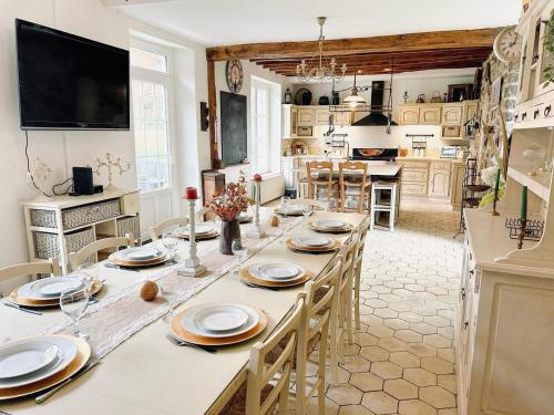 eine große Küche mit einem langen Tisch und Stühlen in der Unterkunft Domaine l'Ermitage Nature & Loisirs, Billard, WiFi, BBQ et Détente in Auger-Saint-Vincent