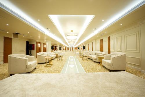 a large room with couches and tables and chairs at Romera Hotel in Jeddah