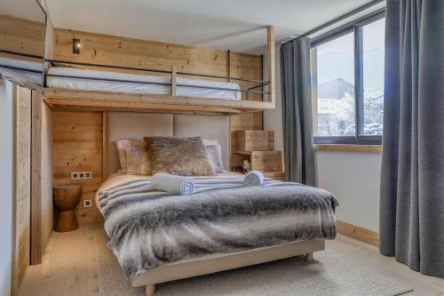 une chambre avec un lit superposé et une grande fenêtre dans l'établissement Megeve les skis aux pieds, à Megève