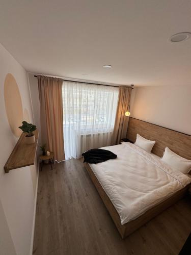 a bedroom with a large bed and a window at CentraLuxury in Piatra Neamţ