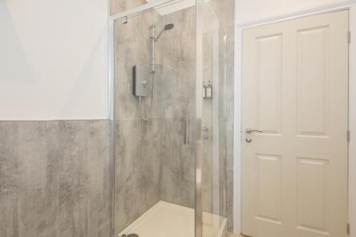 a shower with a glass door in a bathroom at Apartment 3, King's Court in Scarborough