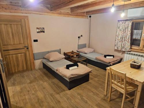 Pokój z dwoma łóżkami i stołem w obiekcie Apartament Rynek 30 w mieście Osieczna
