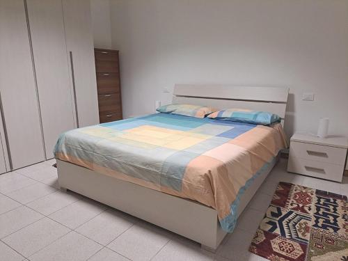 a bedroom with a bed in a room with a rug at Appartamento M2 vicino Ospedale Sacro Cuore - Don Calabria e centro in Negrar
