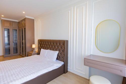 a bedroom with a bed with a mirror on the wall at The Sóng Vũng Tàu Hideaway in Vung Tau