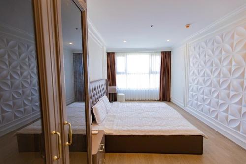 a bedroom with a bed and a mirror at The Sóng Vũng Tàu Hideaway in Vung Tau
