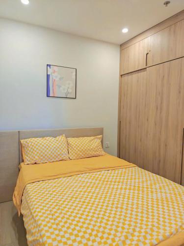 a bedroom with a bed with a yellow blanket at The Sóng Vũng Tàu Hideaway in Vung Tau