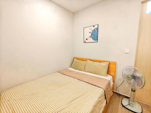 a small bedroom with a bed and a fan at The Sóng Vũng Tàu Hideaway in Vung Tau