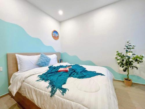 a bedroom with a bed with a blue and white wall at The Sóng Vũng Tàu Hideaway in Vung Tau