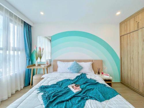 a bedroom with a large bed with a blue headboard at The Sóng Vũng Tàu Hideaway in Vung Tau