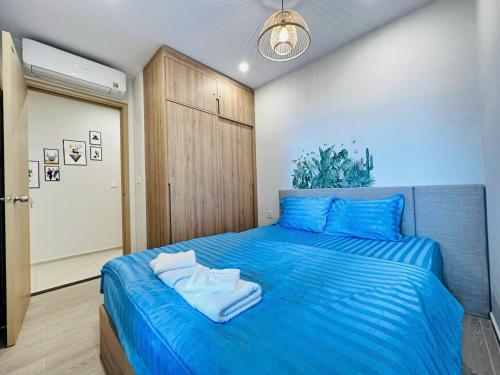 a bedroom with a blue bed with towels on it at The Sóng Vũng Tàu Hideaway in Vung Tau
