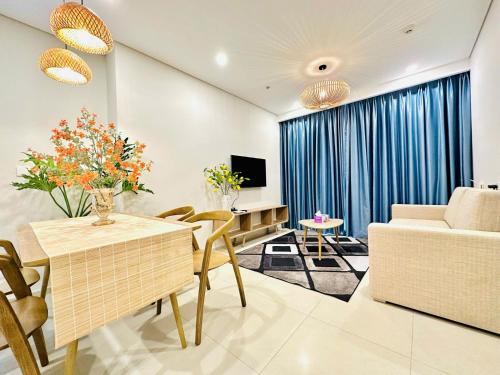 a living room with a couch and a table with chairs at The Sóng Vũng Tàu Hideaway in Vung Tau