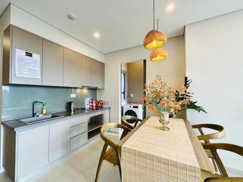 a kitchen with a table with a vase of flowers on it at The Sóng Vũng Tàu Hideaway in Vung Tau