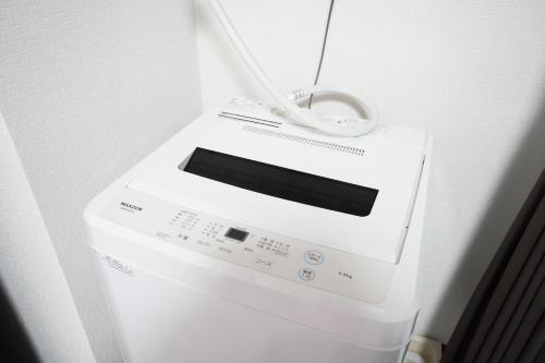a washing machine with a cord on top of it at Charade Kyobashi in Osaka