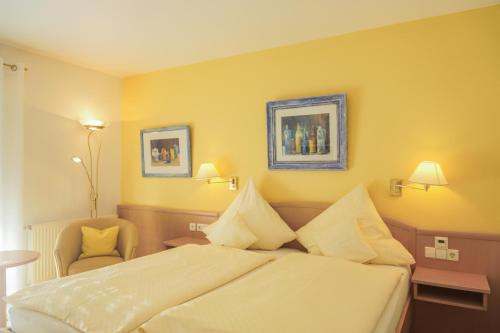 a hotel room with a bed and a chair at Hotel Garni in der Breite in Albstadt