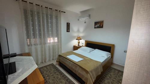 a small bedroom with a bed and a window at Maksi Guest House in Përmet