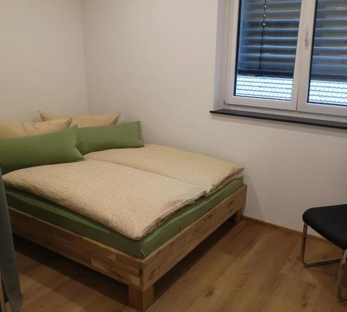 a bed sitting in a room with a window at Franzl Hof Zorell in Ravensburg