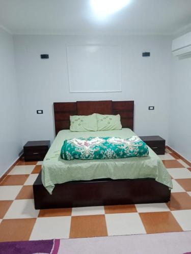 a bedroom with a bed with a checkered floor at الشريف للشقق الفندقيه in Abu Simbel