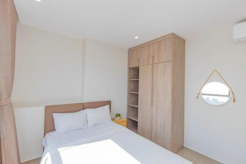 a bedroom with a bed and a wooden cabinet at The Sóng Vũng Tàu Hideaway in Vung Tau
