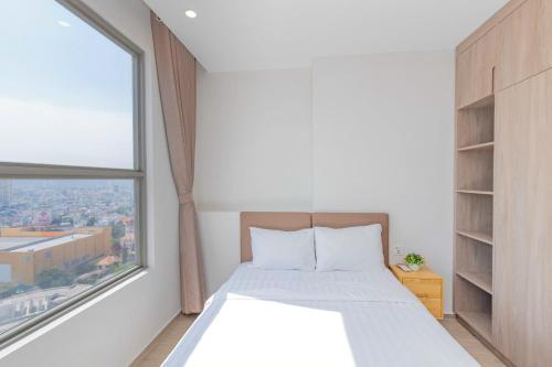 a bedroom with a bed and a large window at The Sóng Vũng Tàu Hideaway in Vung Tau